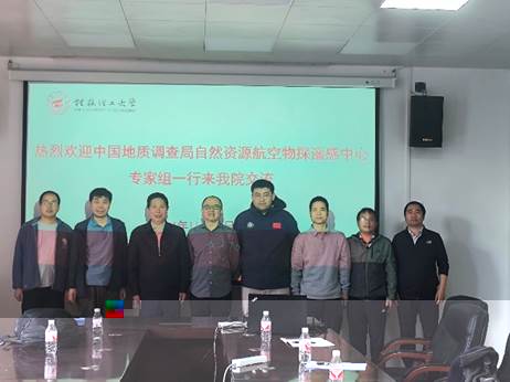 A group of men standing in front of a large screenDescription automatically generated